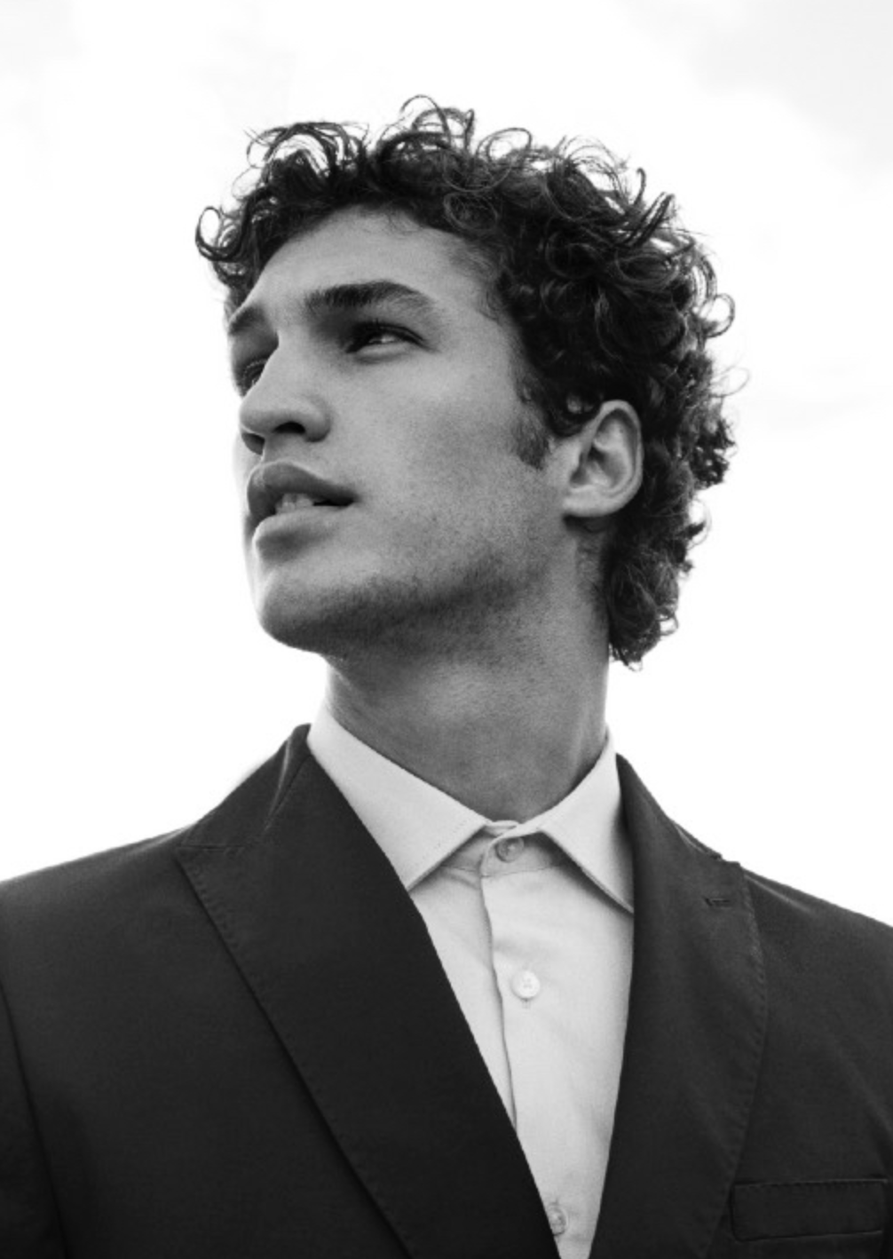 Retrato masculino en blanco y negro con traje y mirada elevada