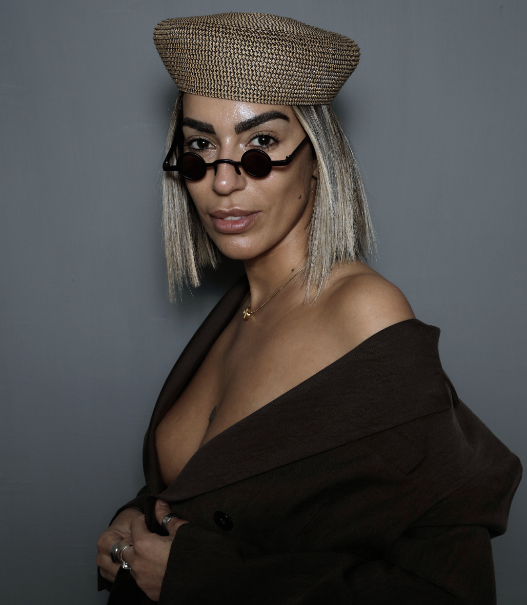 Retrato femenino con sombrero de rafia y gafas redondas